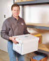 Man holding a storage box in a dry basement