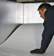 contractor installing TerraBlock™ floor insulation in a Summerside crawl space