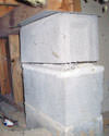Concrete crawl space support posts in Amherst that are showing signs of failure as they sink into the earth.