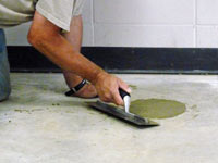 Repairing the cored holes in the concrete slab floor with fresh concrete and cleaning up the Summerside home.