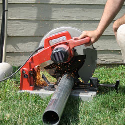 Cutting the support beam for a crawl space jack post outside a Summerside home.