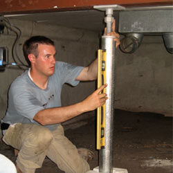 A contractor in Riverview installing a crawl space jack post.