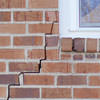 long jagged cracks starting at the corner of a window along a brick wall on a Amherst home