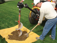 Auguring a hole in the earth for a foundation wall repair system in Summerside