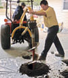 Digging a hole in the garage floor to make room for a wall anchor installation in Grand-barachois, Nova Scotia & New Brunswick