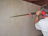 Drilling the hole in the foundation wall for street creep repairs in Rothesay