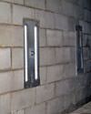 an inside view of foundation wall anchors installed along a basement wall to brace and repair the structure in Saint John