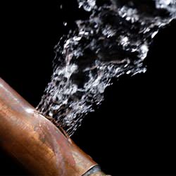 A bursting copper pipe in Dartmouth, with water gushing out.