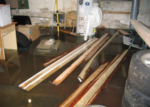 A severely flooding basement in Summerside, with lumber and personal items floating in a foot of water