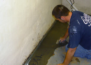 Restoring a concrete slab floor with fresh concrete after jackhammering it and installing a drain system in Grand-barachois.