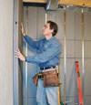 Insulated basement wall panels being placed against a concrete foundation wall in Sydney